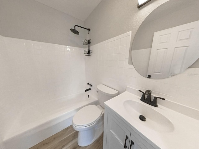 full bathroom with shower / washtub combination, hardwood / wood-style floors, tile walls, vanity, and toilet