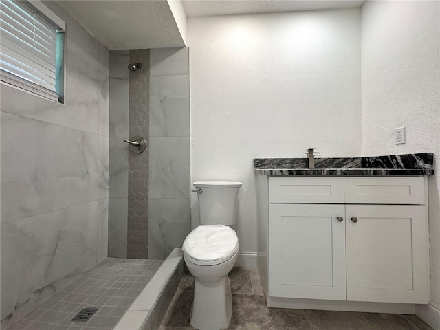 full bath with a shower stall, baseboards, vanity, and toilet