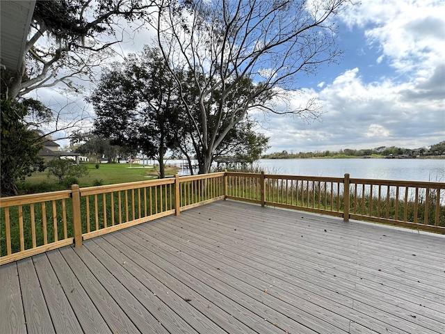 wooden terrace featuring a water view and a lawn