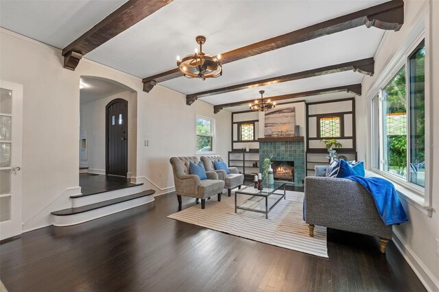 living room with a fireplace, dark hardwood / wood-style flooring, and beam ceiling