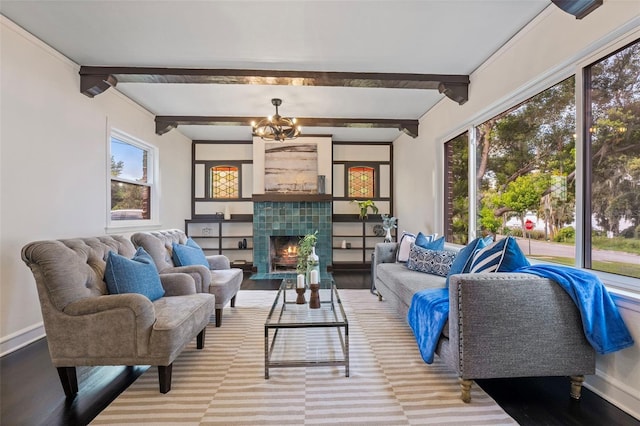 living room with a tile fireplace, beamed ceiling, and baseboards