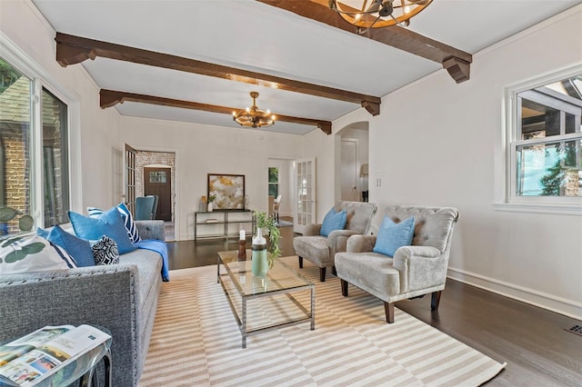 living room featuring baseboards, arched walkways, beamed ceiling, wood finished floors, and a chandelier