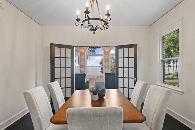 dining area with a notable chandelier, ornamental molding, and wood-type flooring