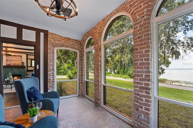 sunroom with a fireplace and a chandelier