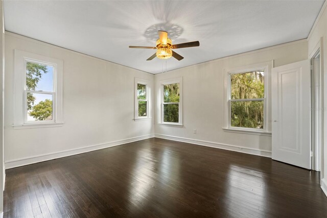 empty room featuring dark hardwood / wood-style flooring, ornamental molding, and ceiling fan