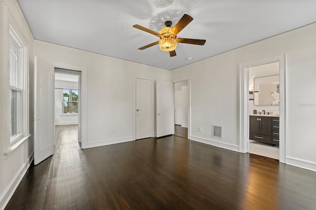 unfurnished bedroom featuring a sink, baseboards, visible vents, and dark wood-type flooring