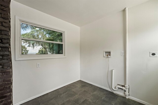 clothes washing area with hookup for an electric dryer, dark tile patterned floors, and hookup for a washing machine