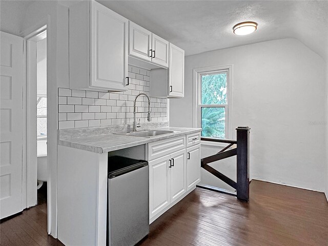 kitchen featuring decorative backsplash, white cabinets, sink, dark hardwood / wood-style floors, and stainless steel refrigerator