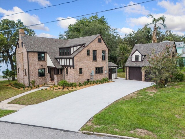 tudor house featuring a garage and a front yard