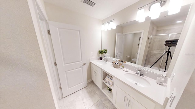 bathroom featuring vanity, toilet, and a shower with door