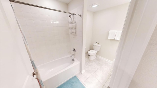 bathroom with tile patterned floors, toilet, and tiled shower / bath