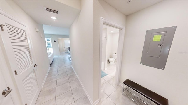 hall featuring electric panel and light tile patterned flooring