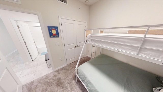 bedroom featuring light carpet and a closet