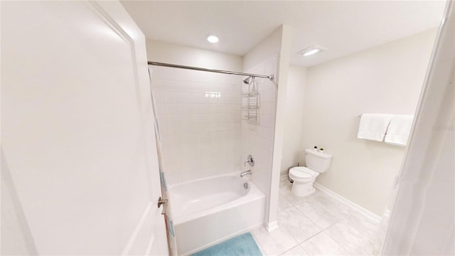 bathroom with tiled shower / bath, toilet, and tile patterned flooring