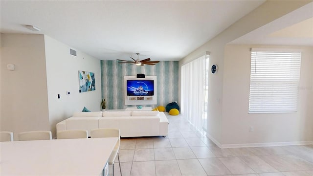 tiled living room featuring ceiling fan and a healthy amount of sunlight