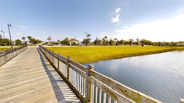 dock area with a water view and a yard