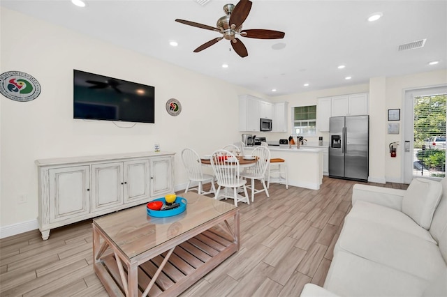 living room featuring ceiling fan and light hardwood / wood-style floors