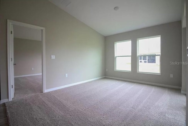 unfurnished room with lofted ceiling and carpet flooring