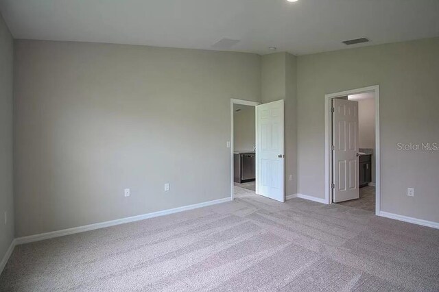 unfurnished bedroom with vaulted ceiling and light colored carpet