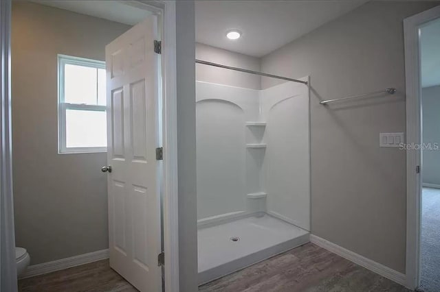 bathroom featuring walk in shower, toilet, and hardwood / wood-style flooring