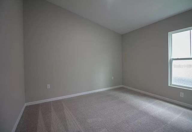 carpeted empty room featuring lofted ceiling and a healthy amount of sunlight