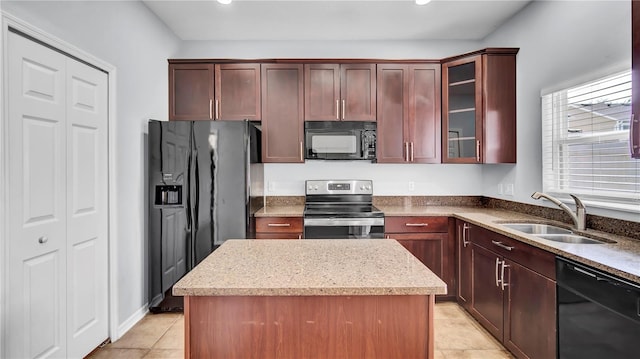 kitchen with sink, black appliances, a center island, light tile patterned floors, and light stone counters