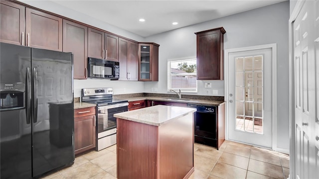kitchen with light tile patterned flooring, a kitchen island, sink, black appliances, and light stone countertops