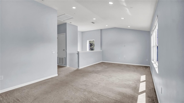 spare room featuring vaulted ceiling and light carpet