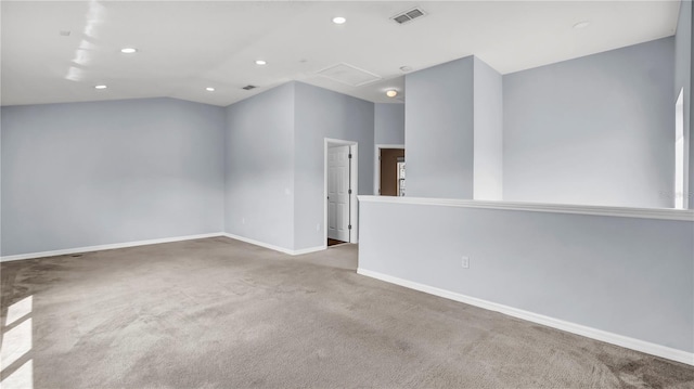 spare room with vaulted ceiling and light carpet