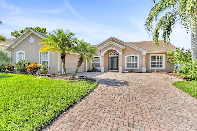 single story home featuring a garage and a front lawn