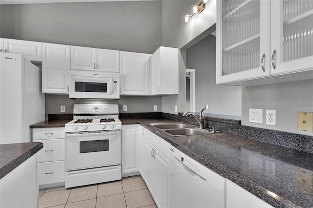 kitchen with sink, light tile patterned floors, white cabinets, and white appliances