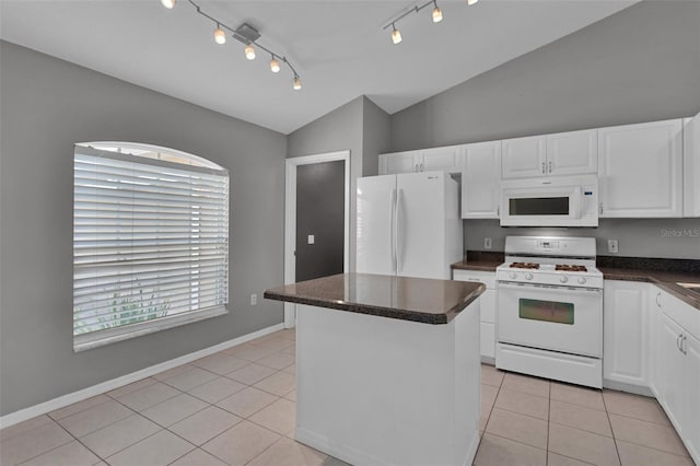 kitchen with white appliances, vaulted ceiling, a kitchen island, and white cabinets