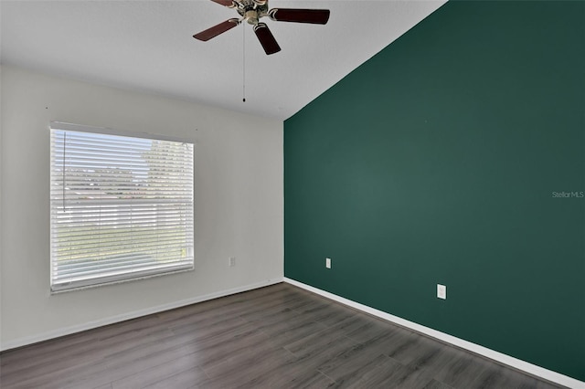 empty room with ceiling fan, wood-type flooring, and vaulted ceiling