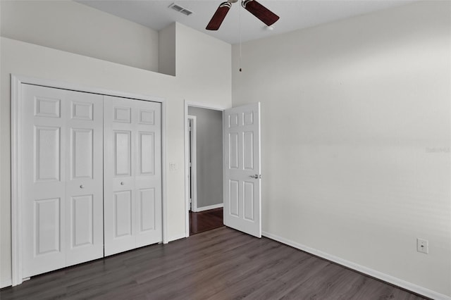 unfurnished bedroom featuring high vaulted ceiling, dark hardwood / wood-style floors, ceiling fan, and a closet