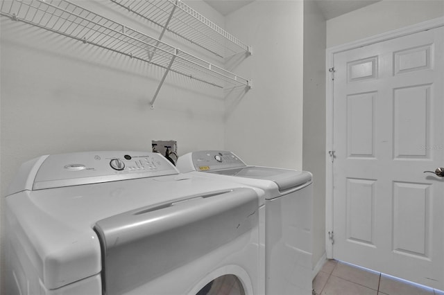 laundry area with light tile patterned flooring and washing machine and dryer