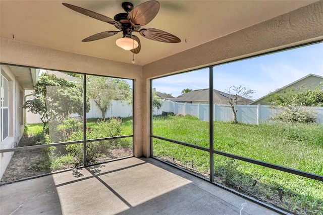 unfurnished sunroom with ceiling fan