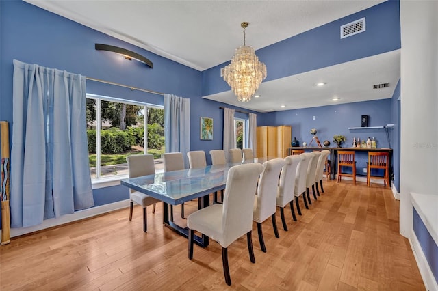 dining space with an inviting chandelier and light hardwood / wood-style flooring