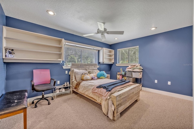 bedroom with a textured ceiling, ceiling fan, and carpet flooring