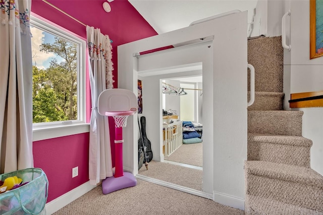 interior space featuring vaulted ceiling, carpet flooring, an inviting chandelier, and a healthy amount of sunlight