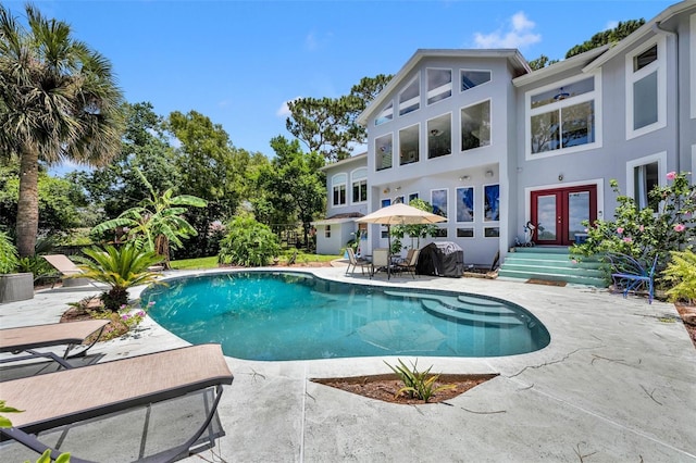 view of swimming pool with grilling area, a patio area, and french doors