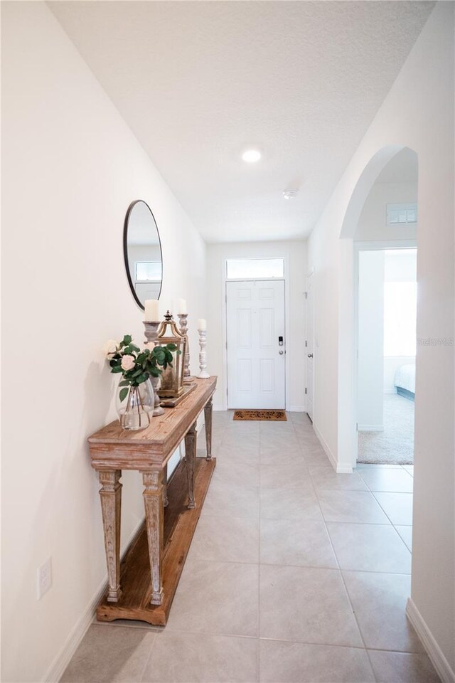 hall with light tile patterned floors