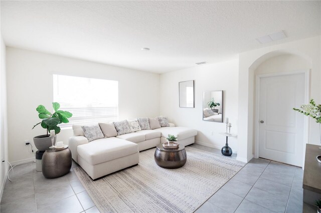 living room featuring light tile patterned floors and a textured ceiling