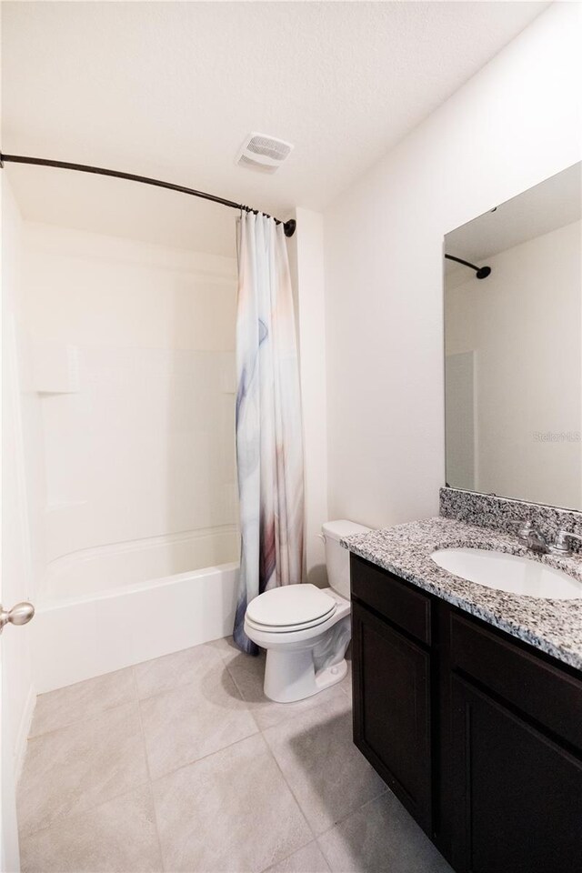 full bathroom with vanity, shower / tub combo with curtain, toilet, and tile patterned floors