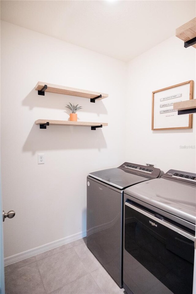 laundry room with light tile patterned flooring and independent washer and dryer