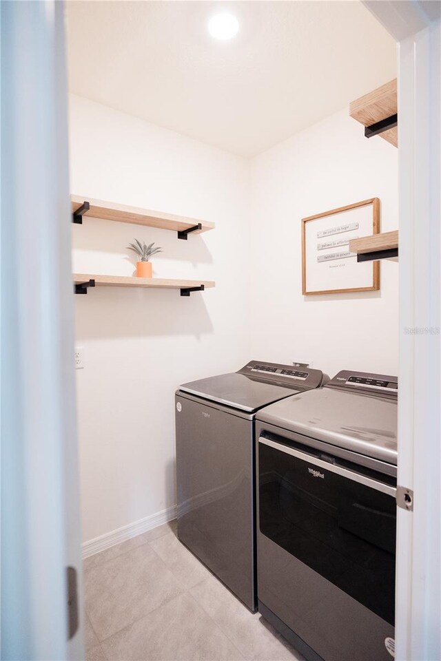 clothes washing area with independent washer and dryer and light tile patterned floors