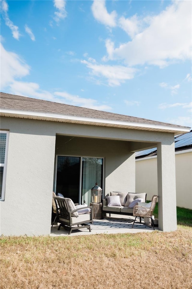 back of house with an outdoor living space and a patio area