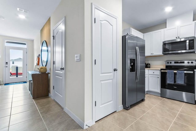 kitchen featuring white cabinets, appliances with stainless steel finishes, and light tile patterned floors