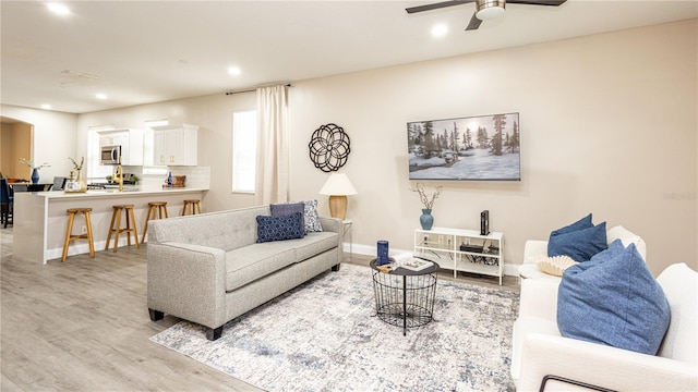 living room featuring ceiling fan and light wood-type flooring