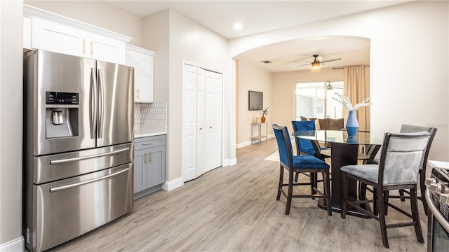 kitchen featuring ceiling fan, backsplash, gray cabinetry, white cabinets, and stainless steel fridge