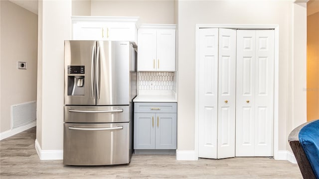 kitchen featuring light wood-type flooring, white cabinets, stainless steel refrigerator with ice dispenser, and gray cabinetry